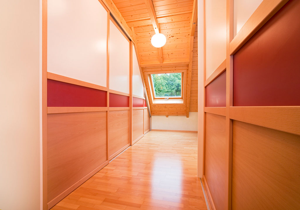 Kleiderschrank unter dem Dach Holz Eichenhaus Gleittüren Schiebetüren Gleittüren, Trennwände und Schrankmöbel von der Schreinerei WERNER AG im Eichenhaus Laufach